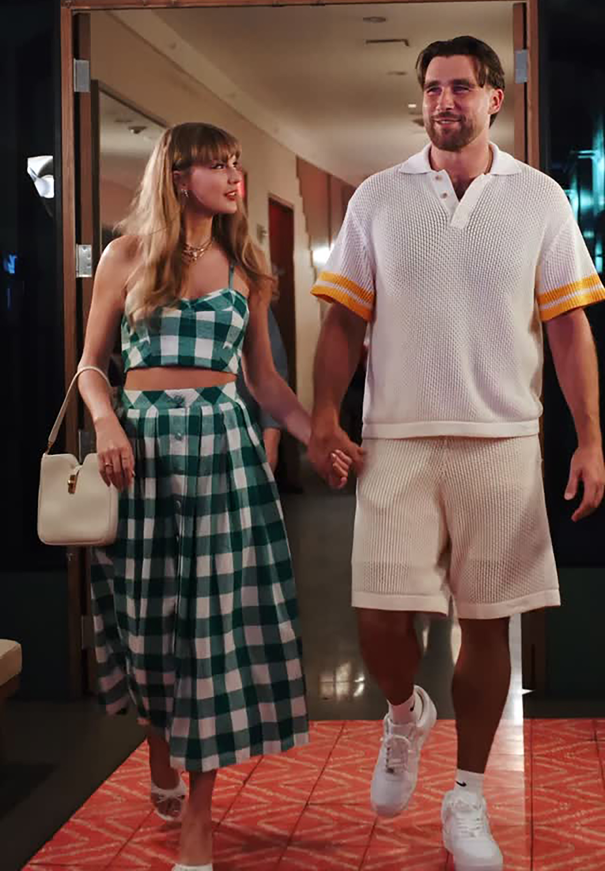 Taylor Swift and Travis Kelce holding hands while walking.