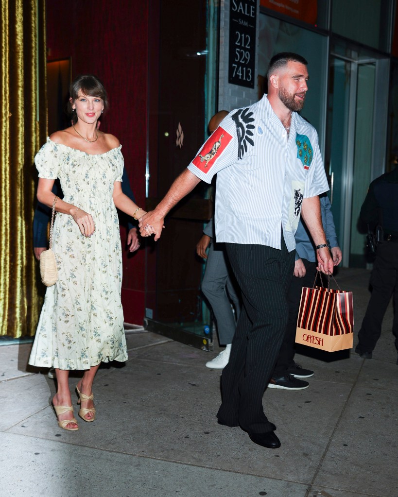 Taylor Swift and Travis Kelce hold hands while walking together in New York City.