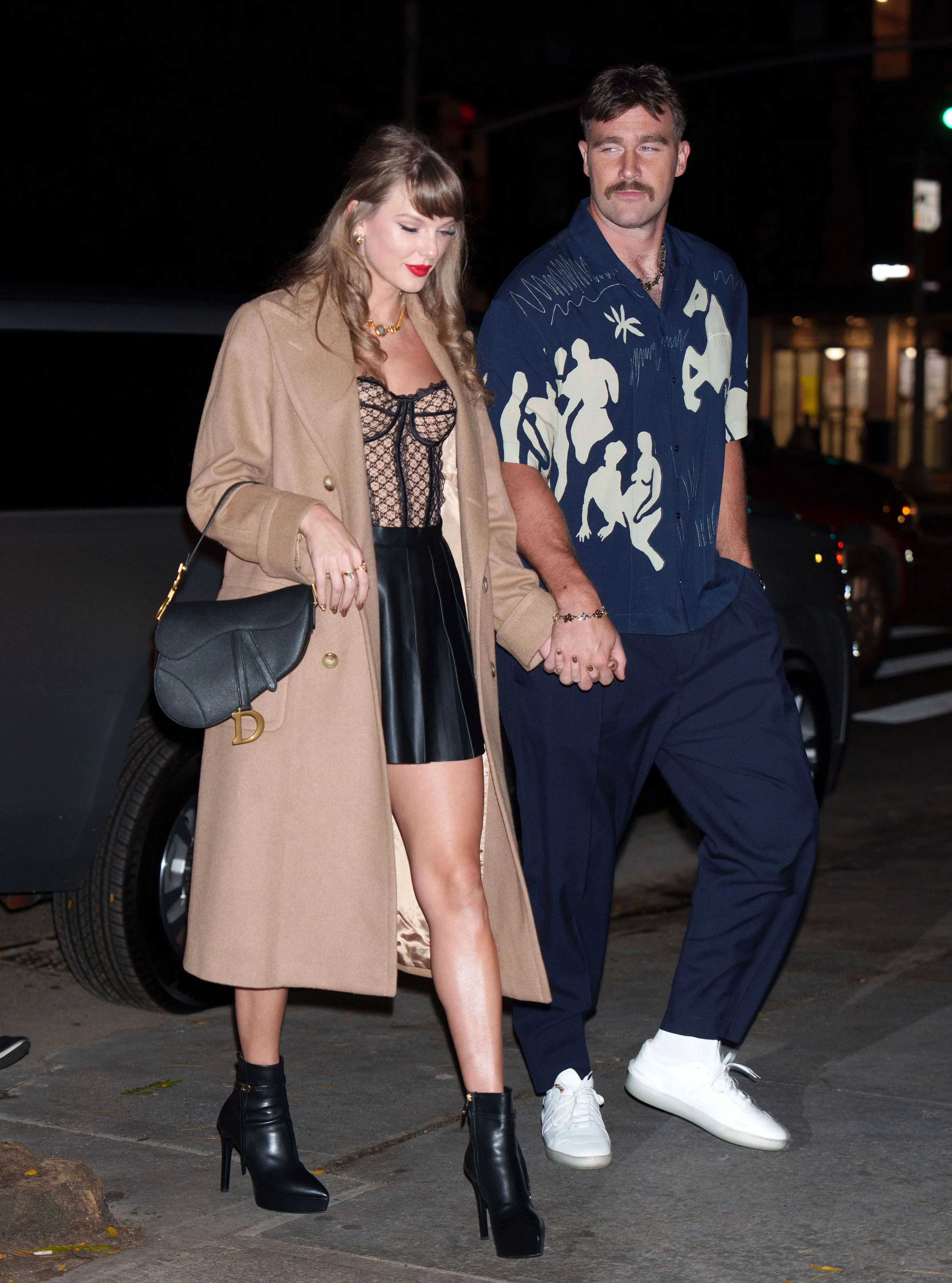 Taylor Swift and Travis Kelce holding hands while walking in New York City.