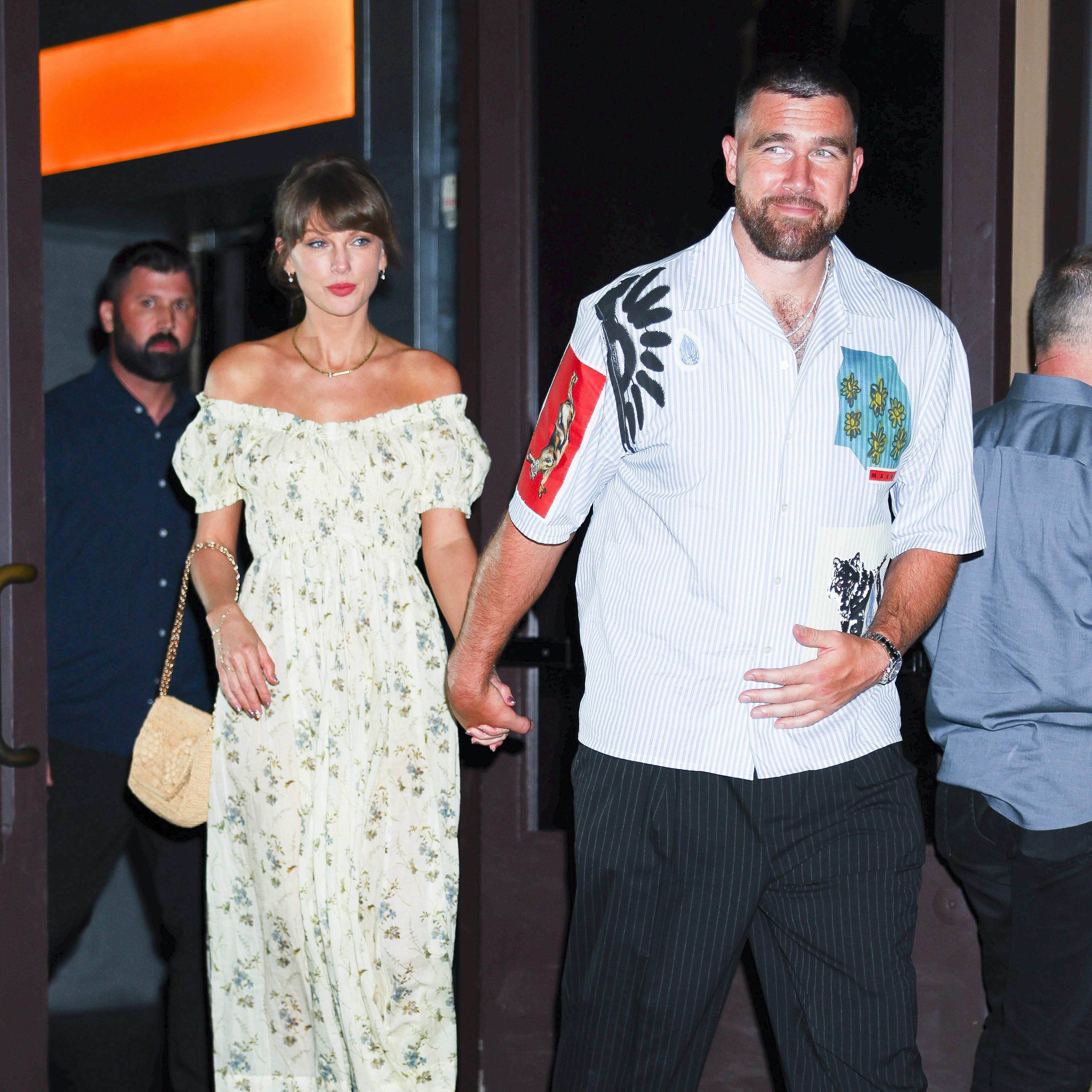 Taylor Swift and Travis Kelce holding hands while leaving Zero Bond.