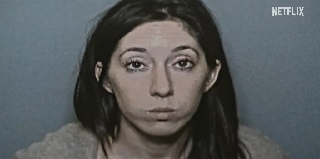 Mugshot of a woman with dark hair against a blue background.