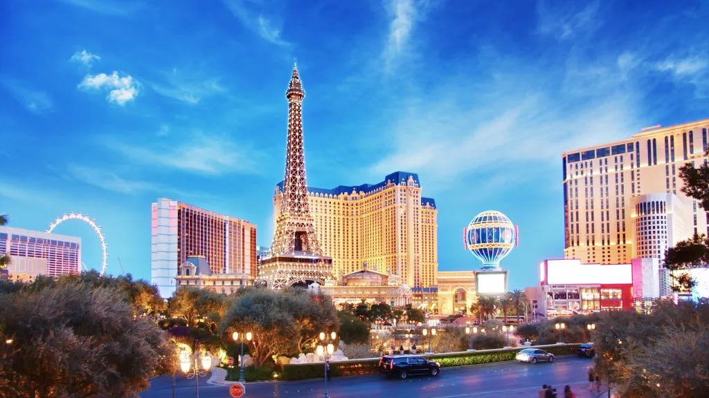 Las Vegas Strip cityscape featuring the Eiffel Tower Experience and other hotel-casinos at dusk.