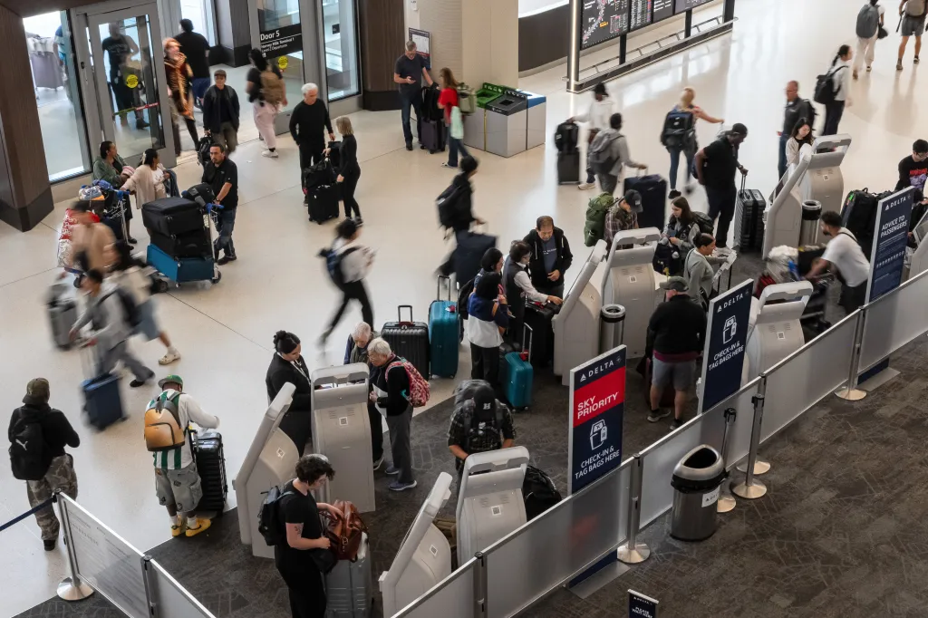 Travelers use self-service kiosks in the Delta check-in area at San Francisco International Airport (SFO).