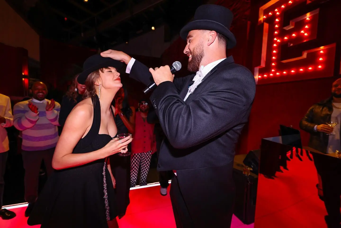 Travis Kelce gives Taylor Swift the "22" hat at her party.