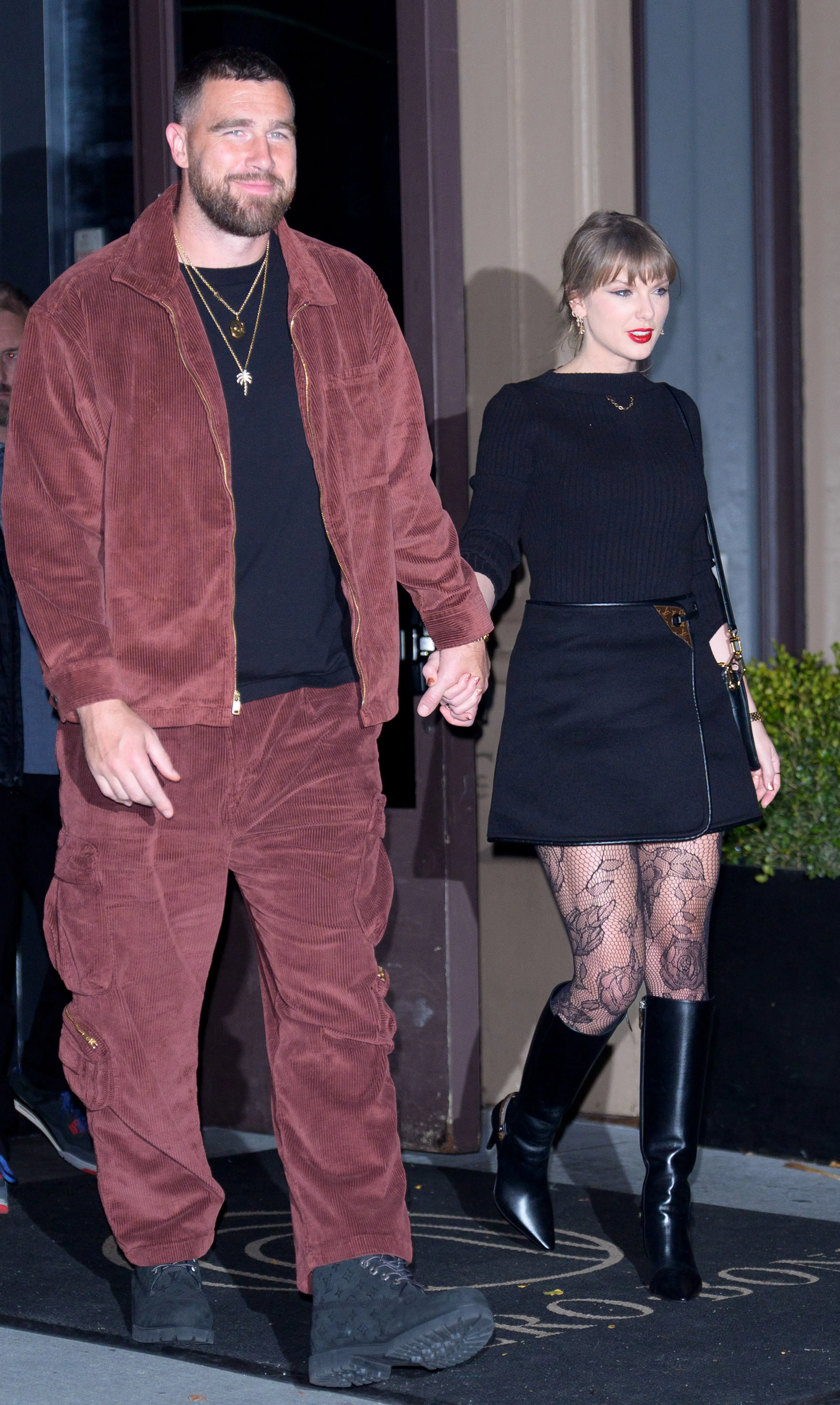Travis Kelce and Taylor Swift holding hands while walking in New York City.