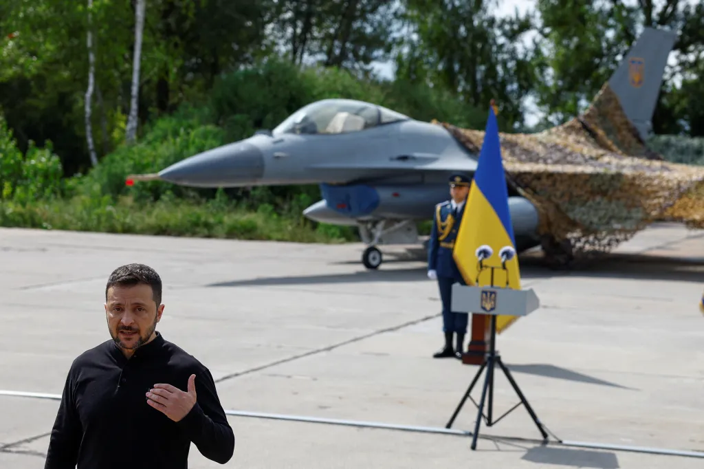 Ukraine's President Zelenskiy speaks to the media in front of an F-16 fighting aircraft.