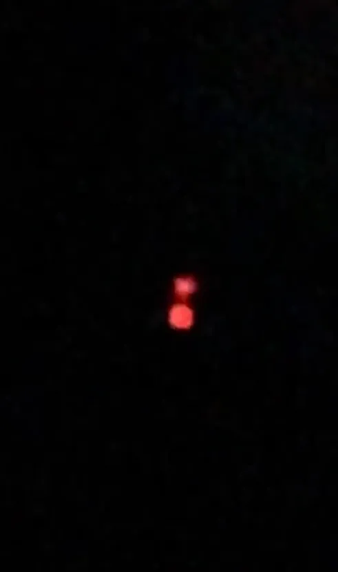 Two glowing red orbs in a dark sky.