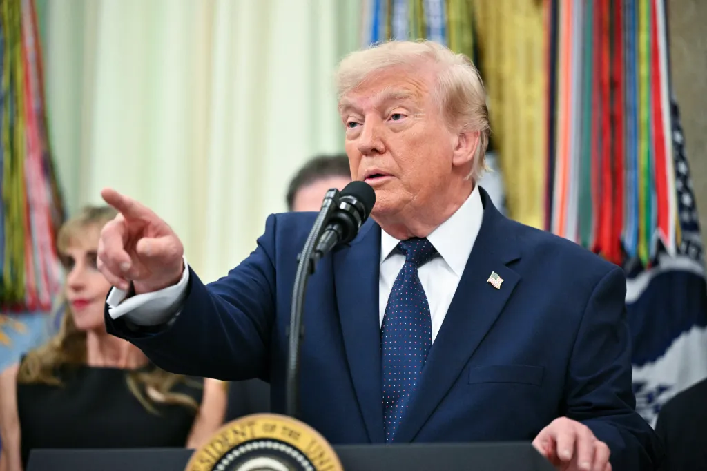 US President Donald Trump speaks at a podium in the Oval Office.