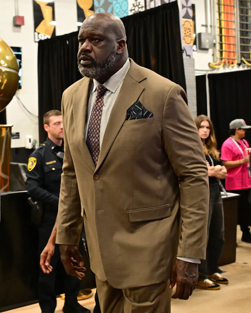 Shaquille O'Neal in a brown suit arriving at the arena before a basketball game.