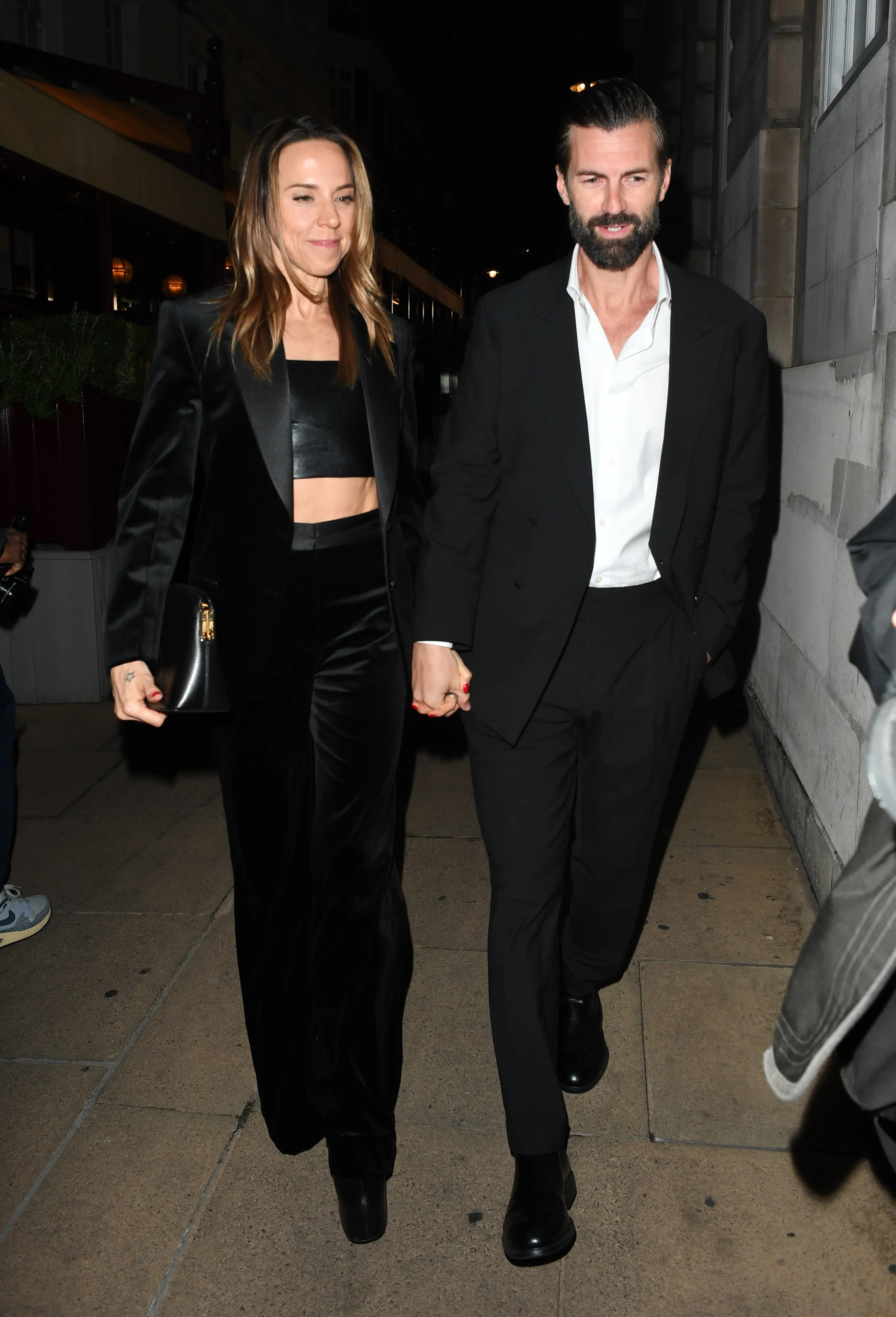 Melanie Chisholm and Chris Dingwall holding hands and walking.