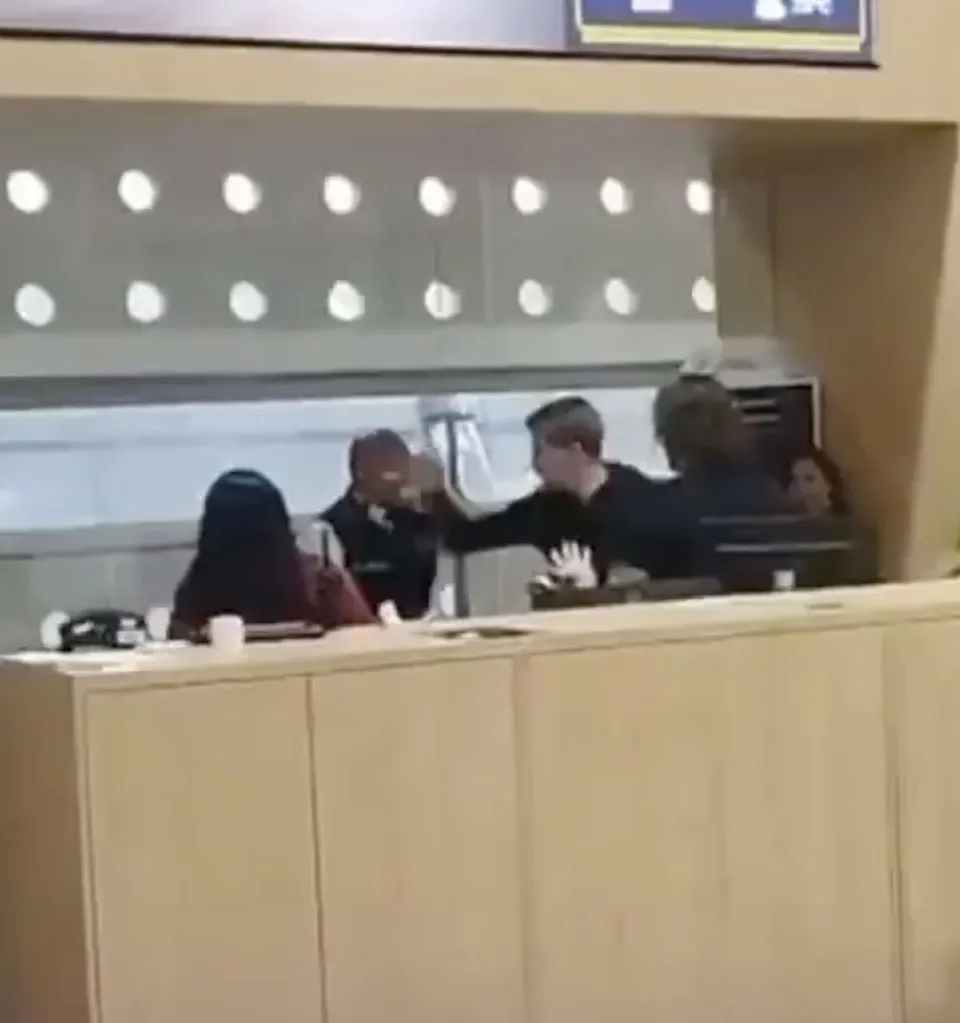 Video grab showing passengers attacking airport staff.