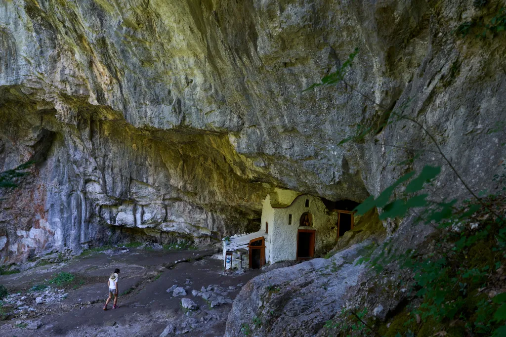 A visitor approaches a chapel at the Holy Cave of St. Dionysios in the Enipeas Gorge on Mount Olympus in northern Greece.
