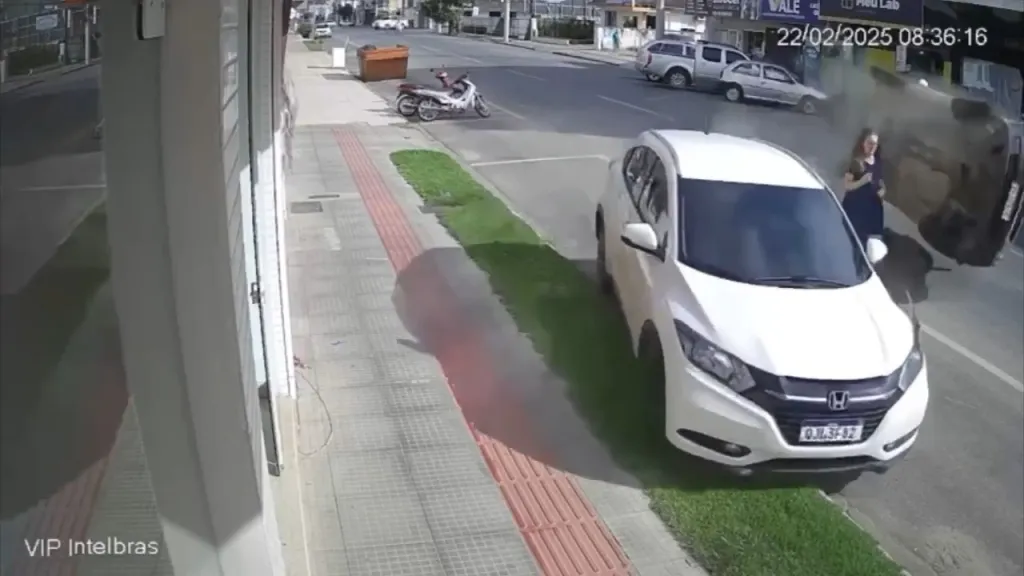 A woman narrowly avoided a pickup truck that crashed into a parked vehicle on the street.