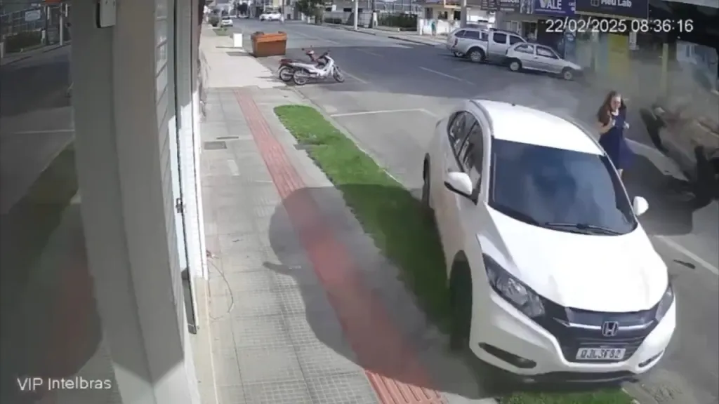 A woman narrowly missed by a pickup truck crashing into a parked vehicle.