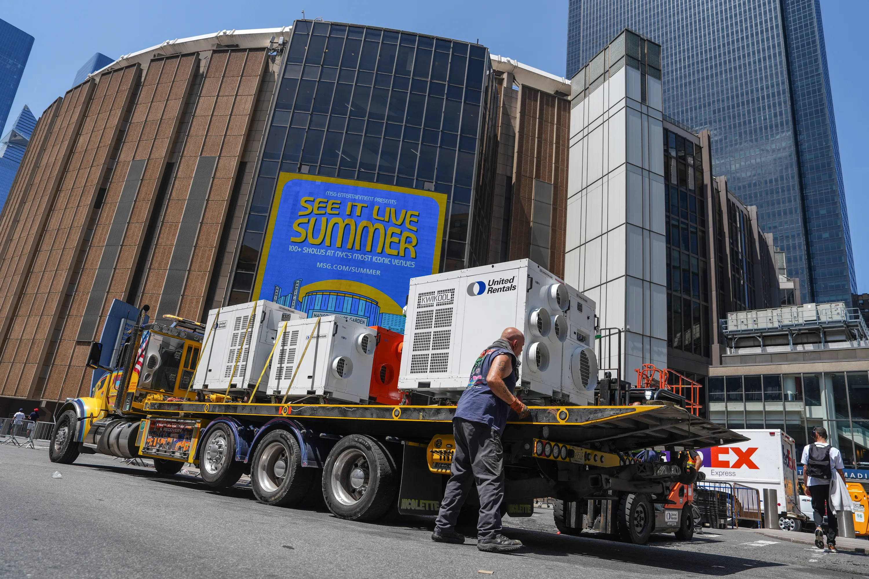 A worker unloads portable air-conditioning units outside of Madison Square Garden.