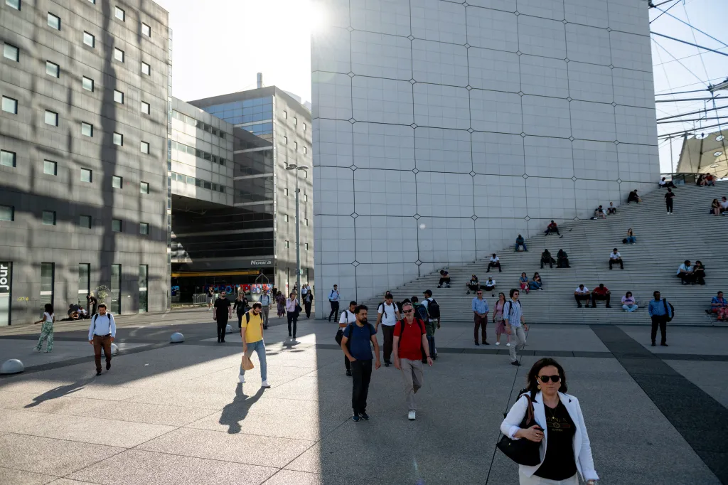 Workers and others find shade on the steps of the Grande Arche during high temperatures in Paris.