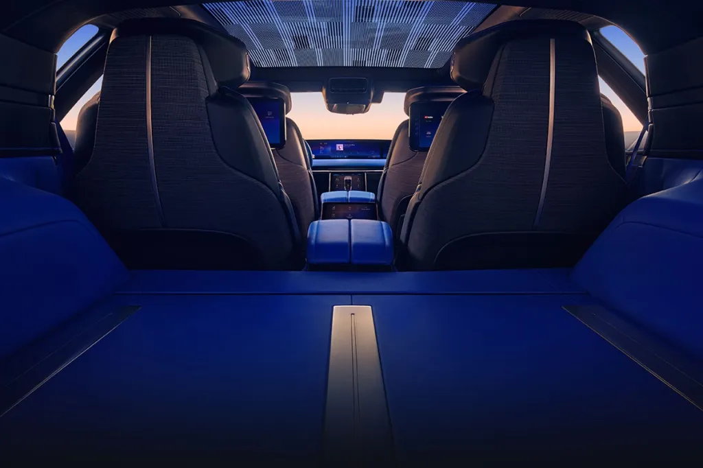 Interior of the Cadillac CELESTIQ, showing the back of the front seats, rear infotainment screens, and the blue rear cargo area.