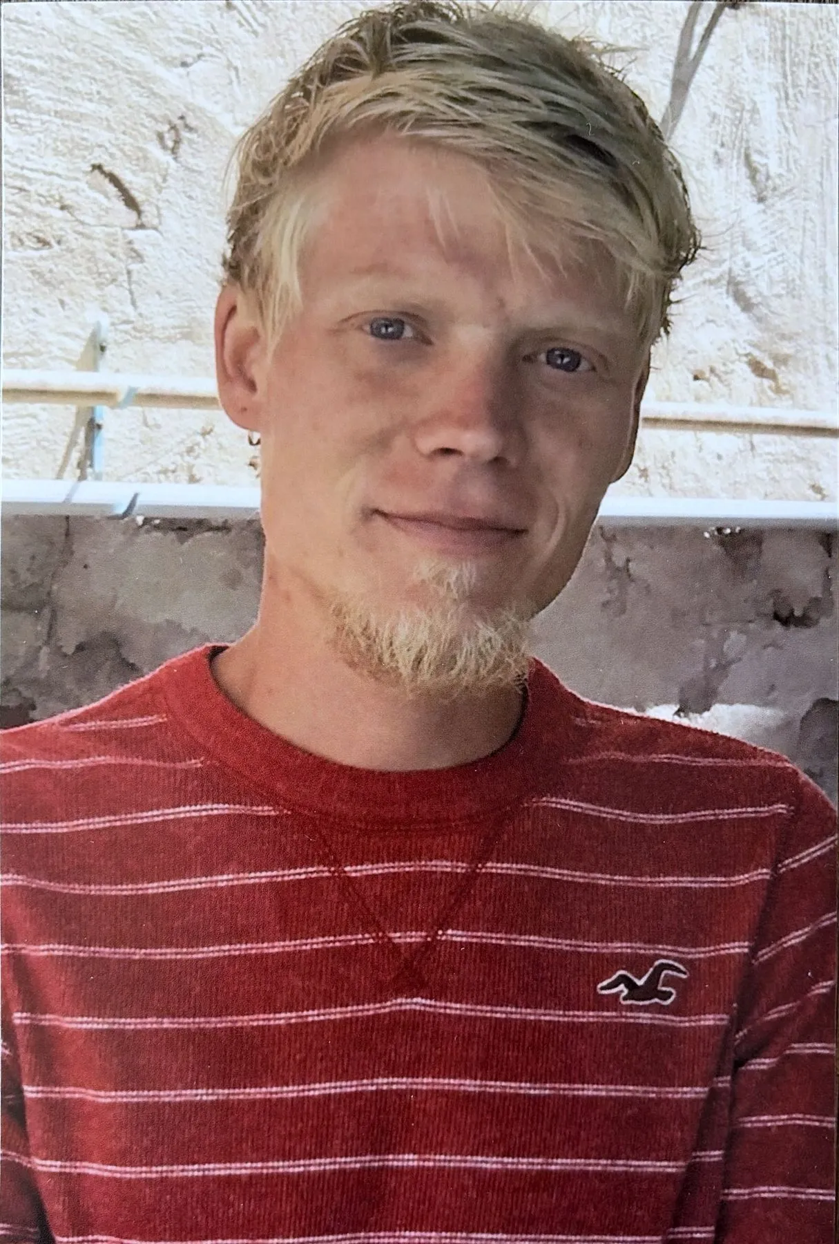 A man with blonde hair and a goatee smiles at the camera.