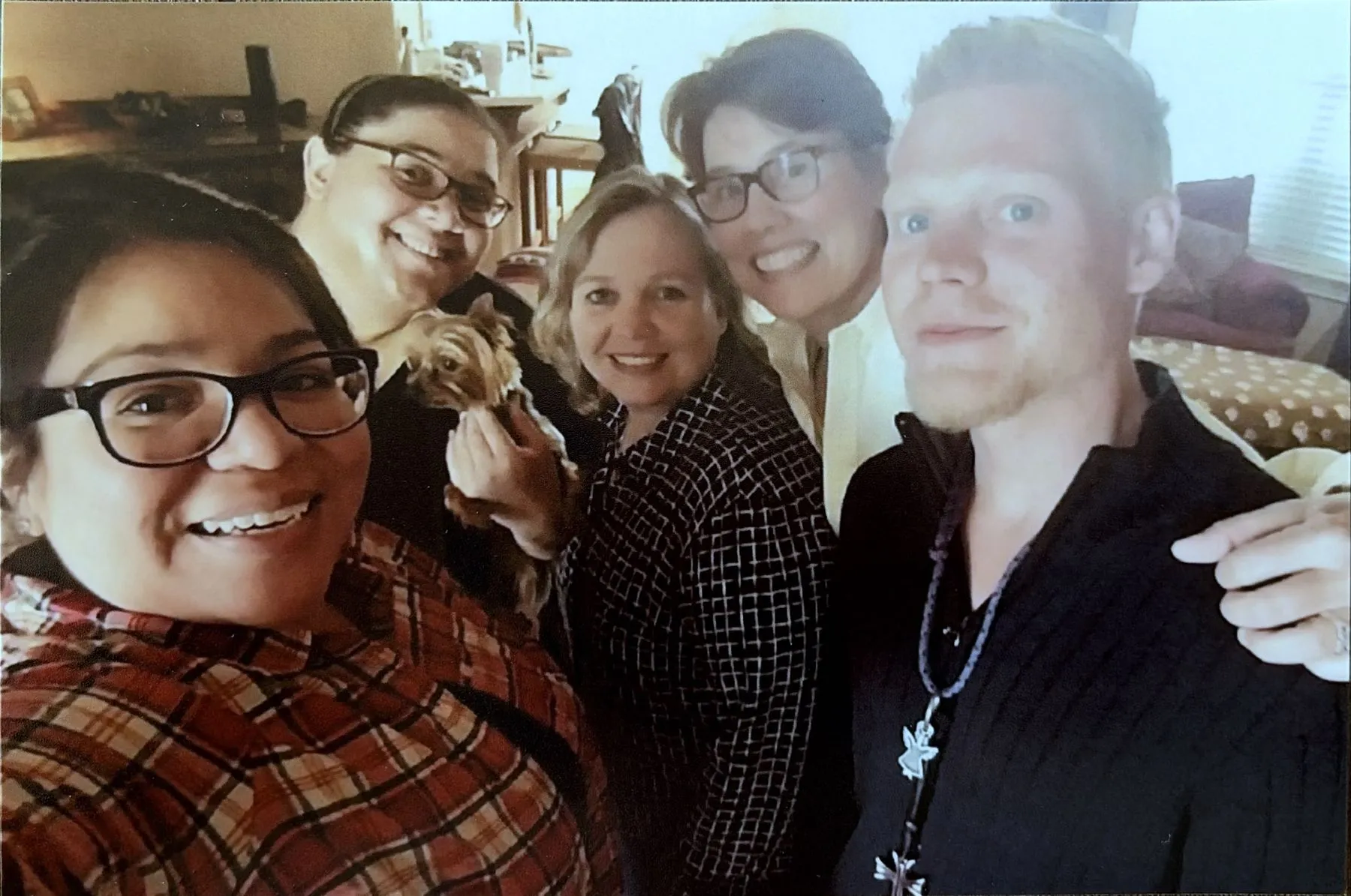 A group of five people, including Blake Garret, posing with a small dog.