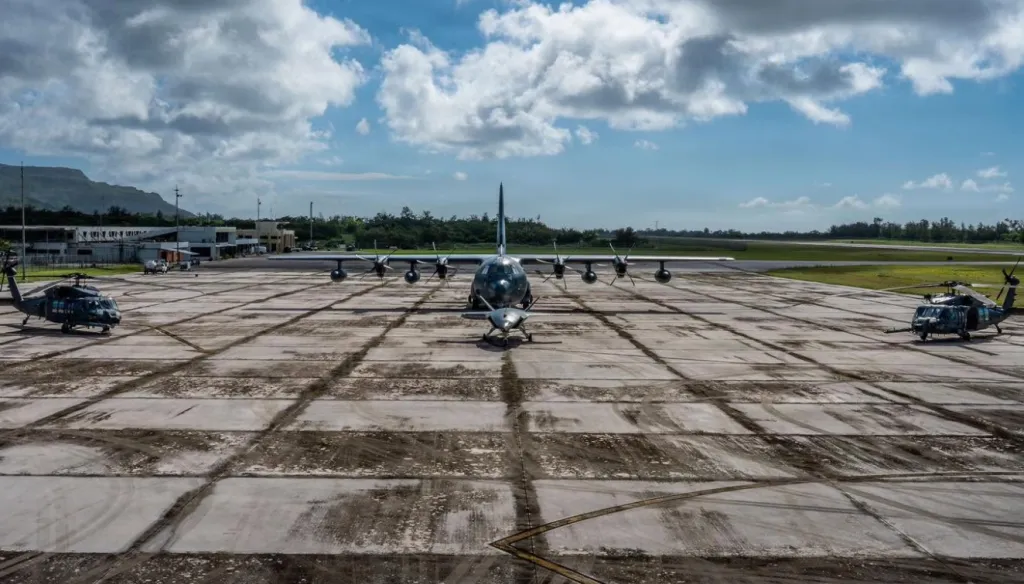 C-130 Hercules cargo plane and two Blackhawk helicopters on a concrete tarmac at Davis-Monathan Air Force Base.