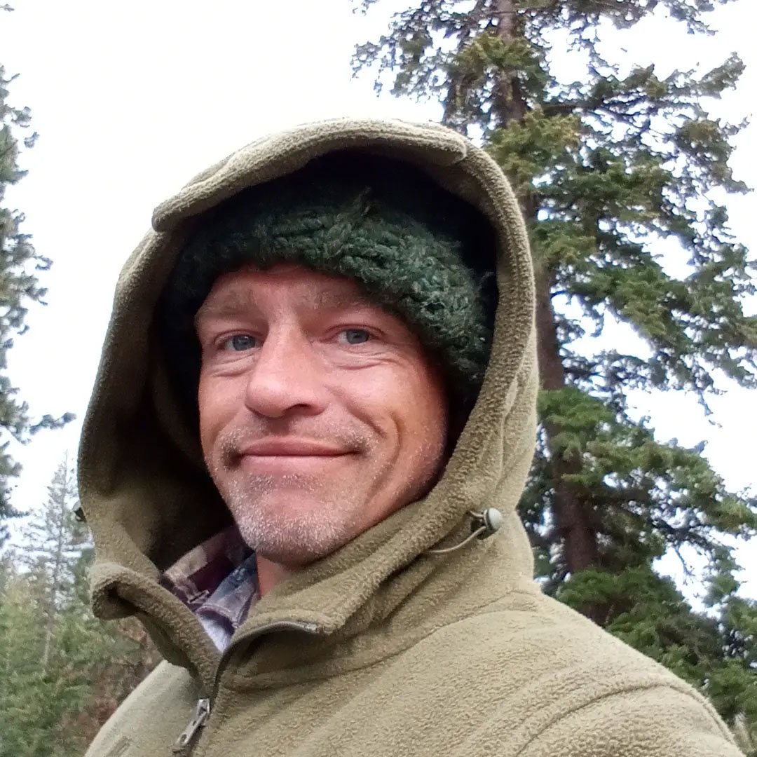 Reality star Matt Brown wearing a hooded jacket and knit cap outdoors.