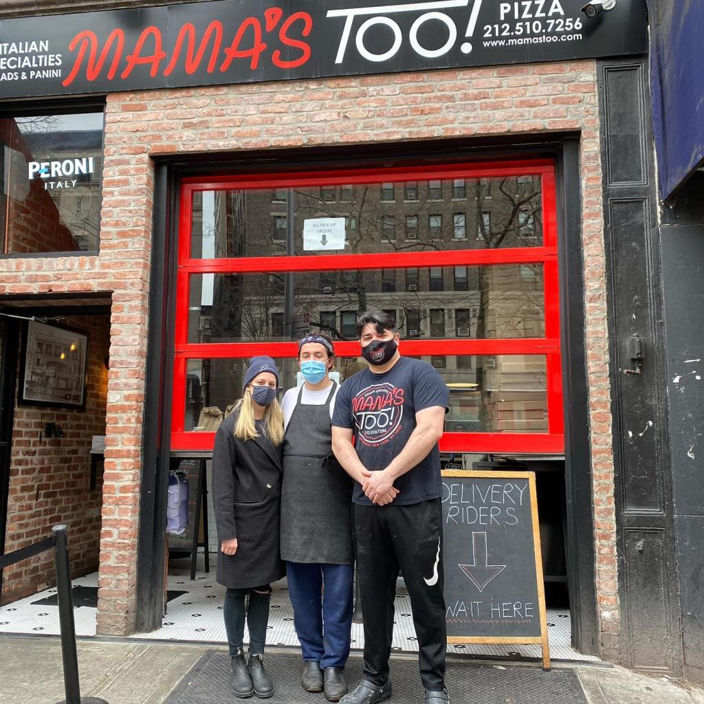 Three people, two men and one woman, standing outside Mama's Too Pizzeria.
