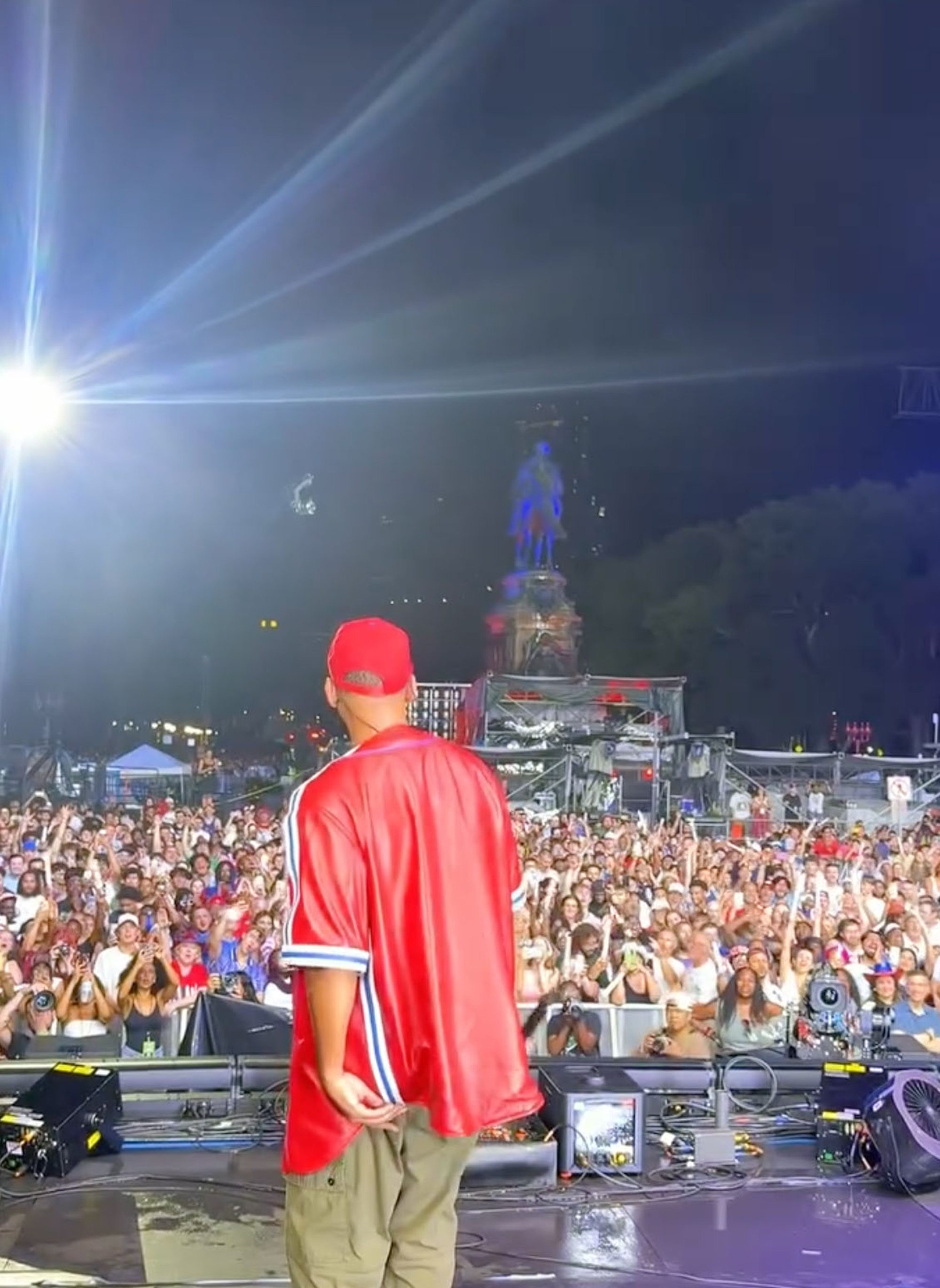Will Smith on stage facing a large crowd at a nighttime outdoor concert.