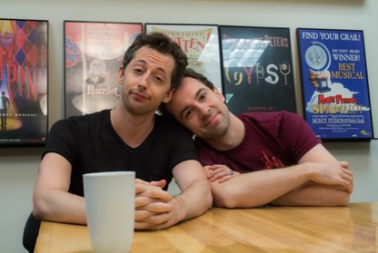 Josh Grisetti and another man smiling at the camera, with the man on the right resting his head on Grisetti's shoulder.