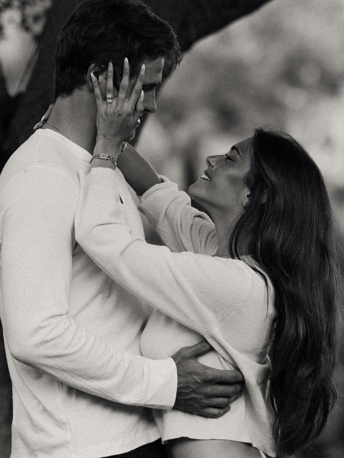 Madison Beer and Justin Herbert embraced, showing an engagement ring on Beer's hand.