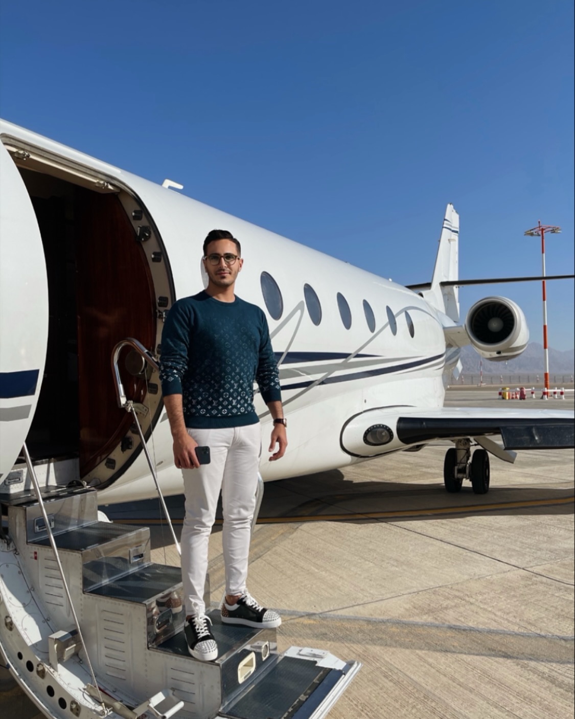 Simon Leviev, the "Tinder Swindler", stands on the steps of a private jet.