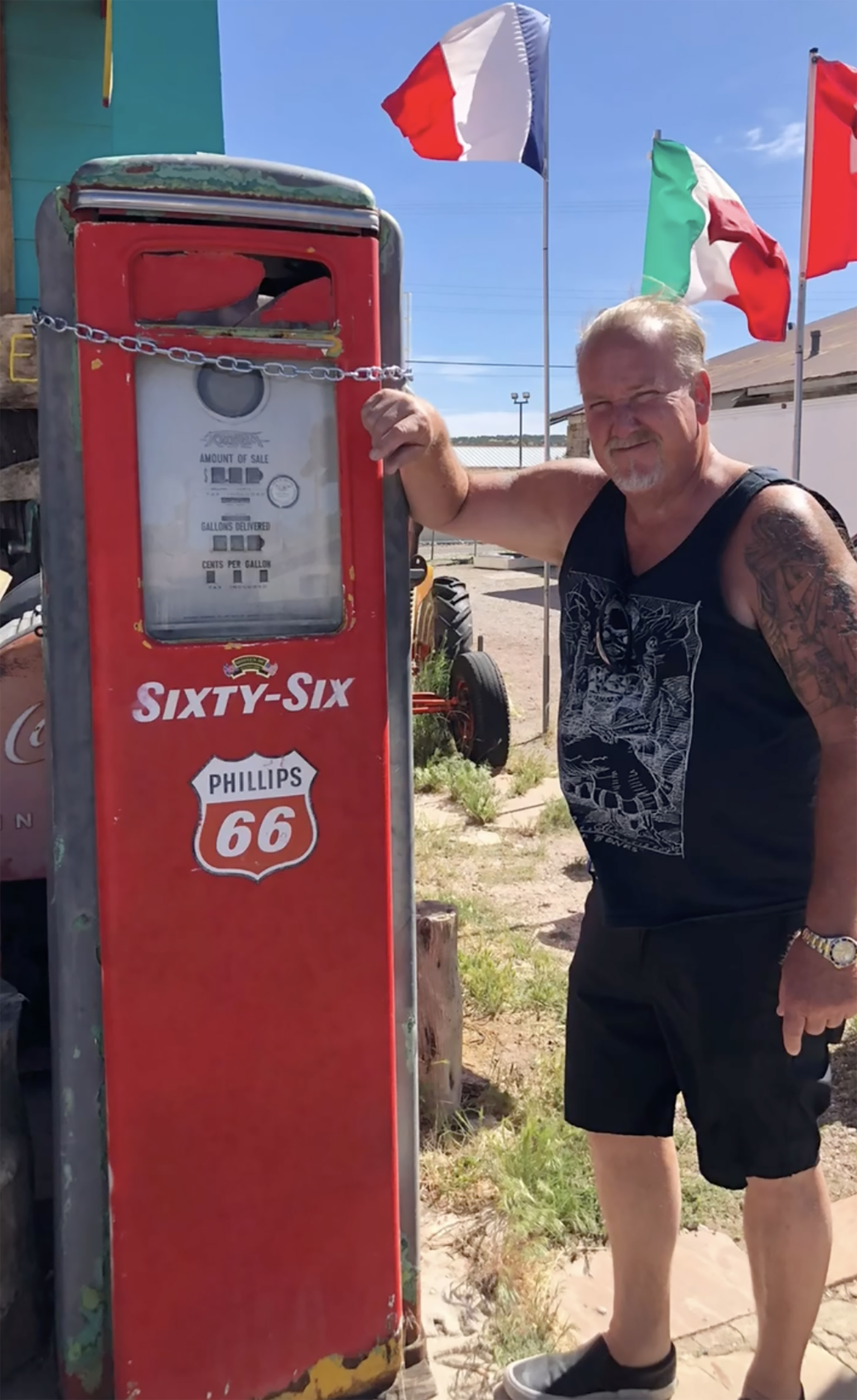 Darrell Sheets smiling next to a vintage red Phillips 66 gas pump.