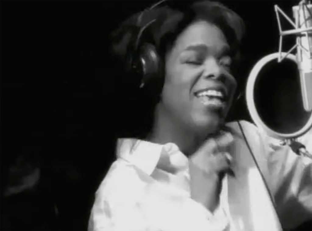 Oprah Winfrey singing into a microphone in a recording studio.
