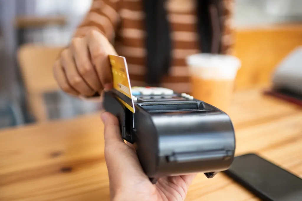 A person using a credit card to pay on a payment terminal.