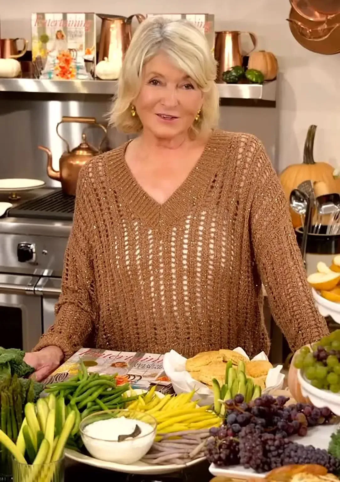 Martha Stewart with a display of fall vegetables and a cookbook.