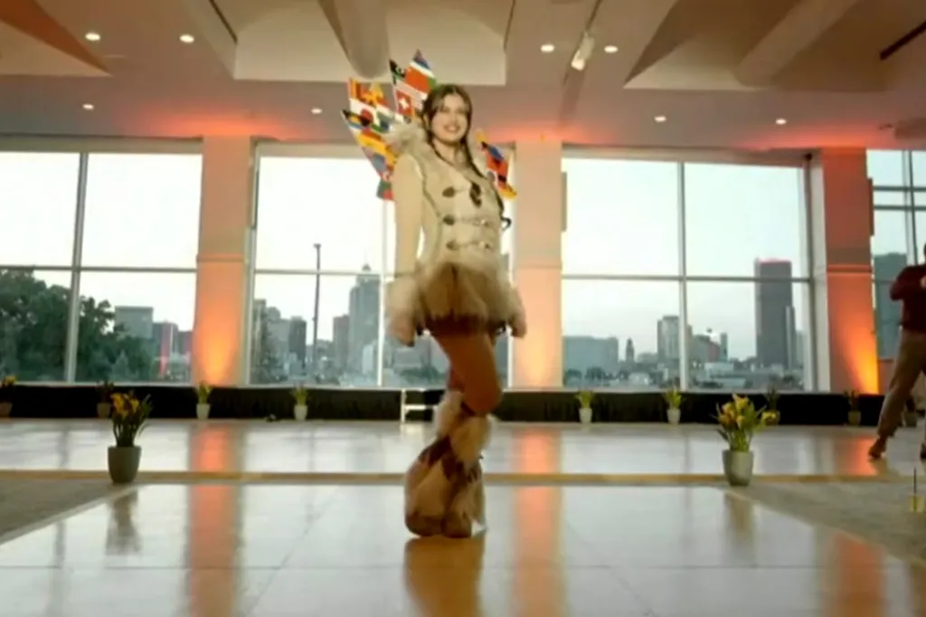 A model on a runway in an outfit featuring flags and fur.