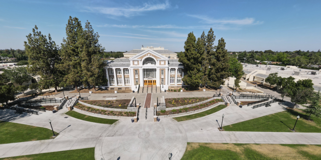 Aerial view of Fresno High School, a large white building with pillars, steps, and wide walkways.