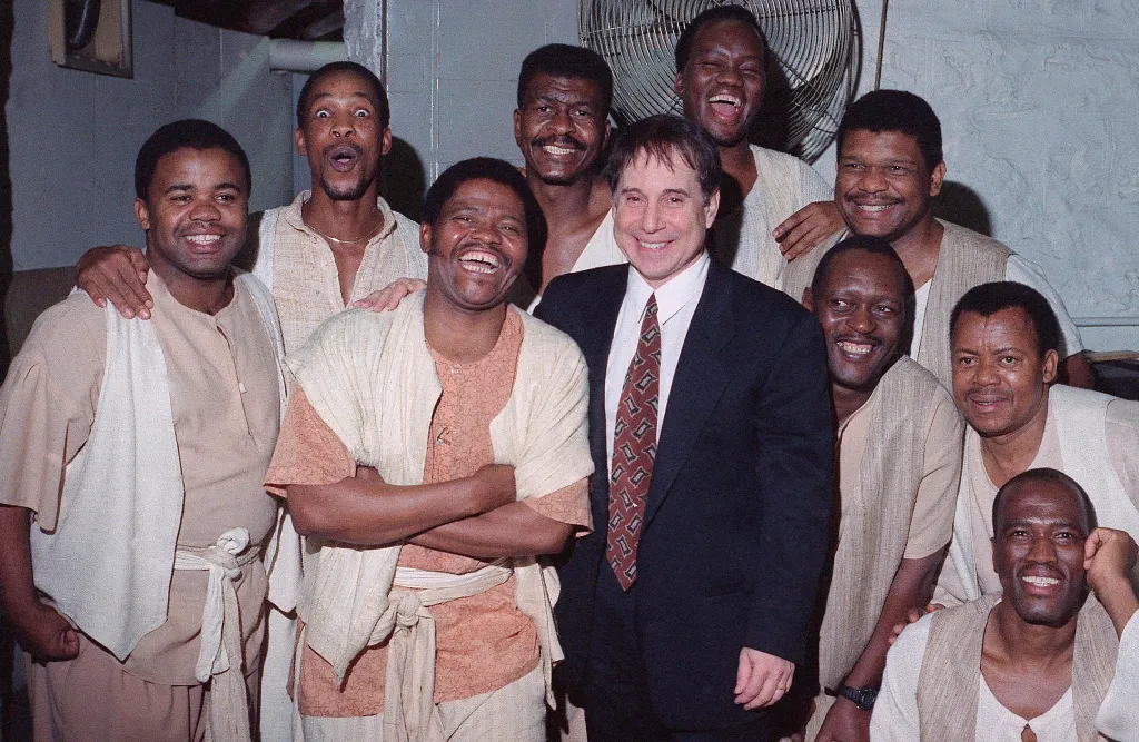 Joseph Shabalala and Paul Simon posing with Ladysmith Black Mambazo in 1993.