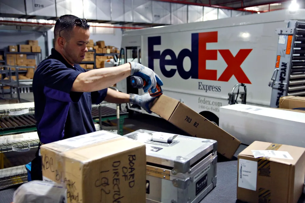 Charlie Romero scans outgoing packages inside a FedEx facility.