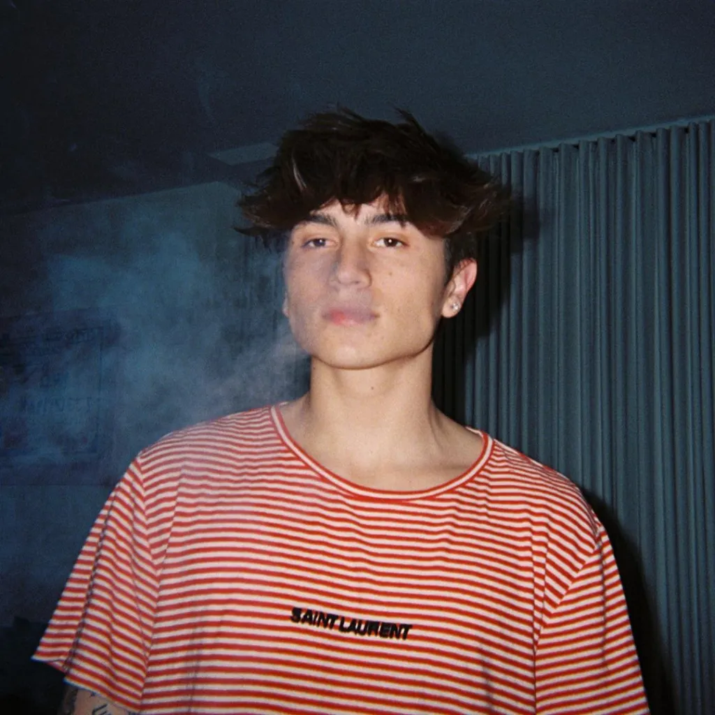 TikTok star Cooper Noriega in a red and white striped shirt with smoke near his mouth.