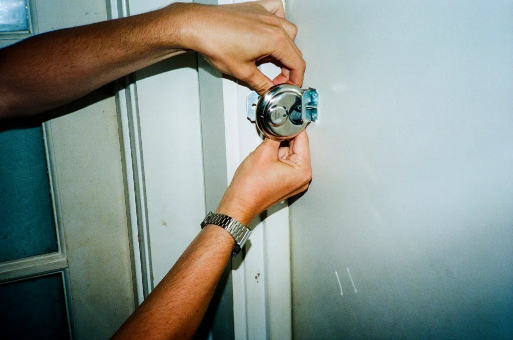 A person installing a new deadbolt on a door.