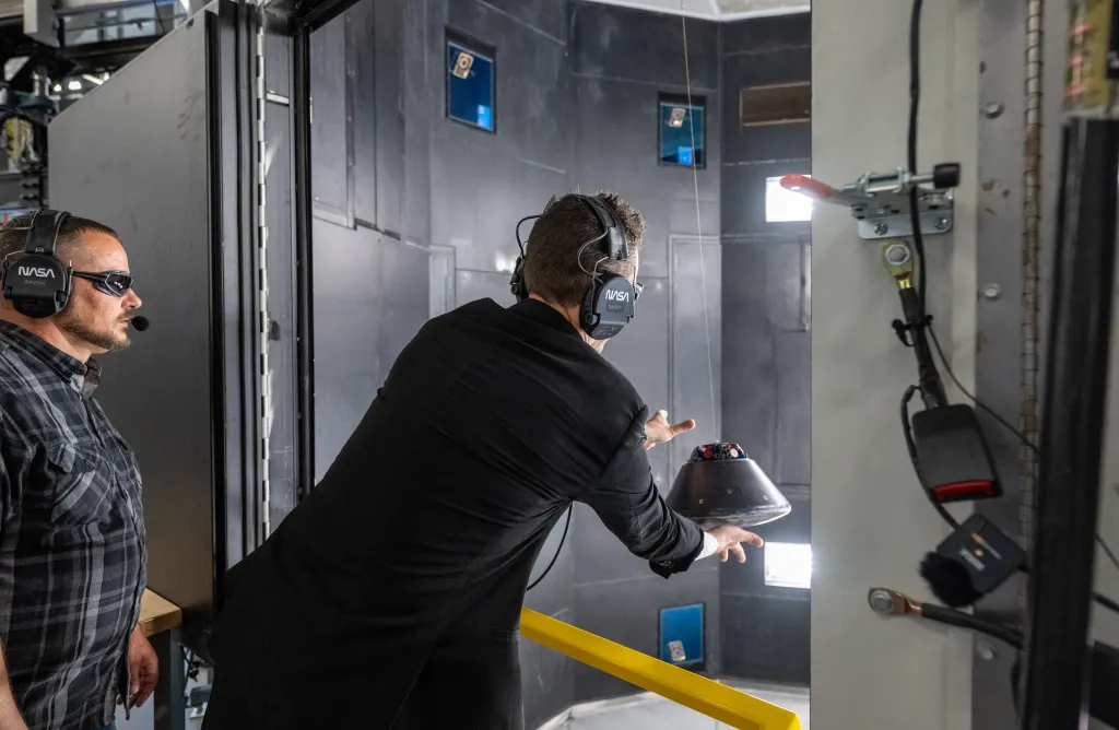 Jared Isaacman launches a scale model of the Orion capsule during a demonstration at the Flight Dynamics Research Facility.