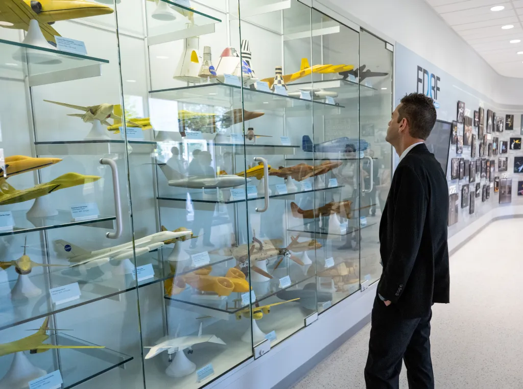 Jared Isaacman views scale models of aircraft at the Flight Dynamics Research Facility.