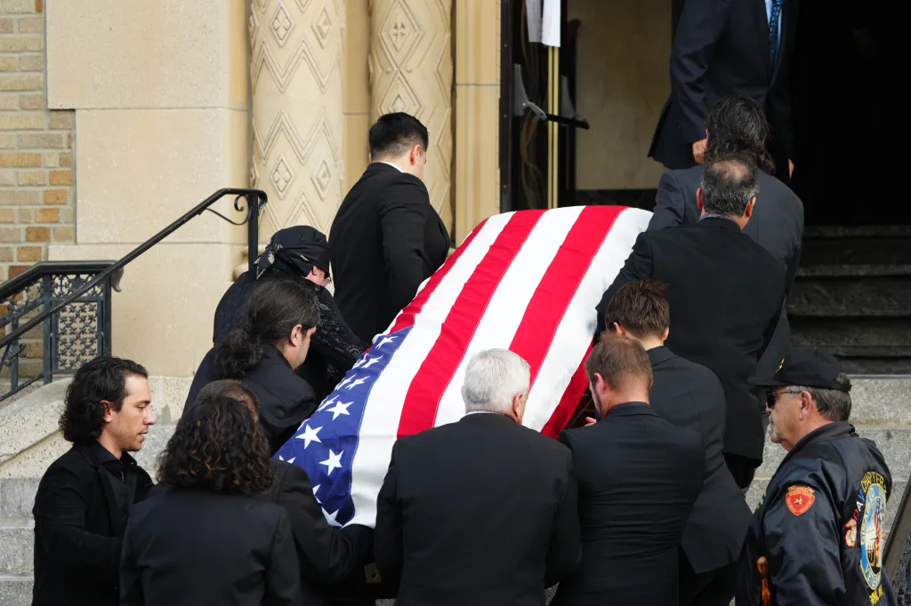 Pallbearers carrying the flag-draped casket of actor Vincent Pastore during his funeral.
