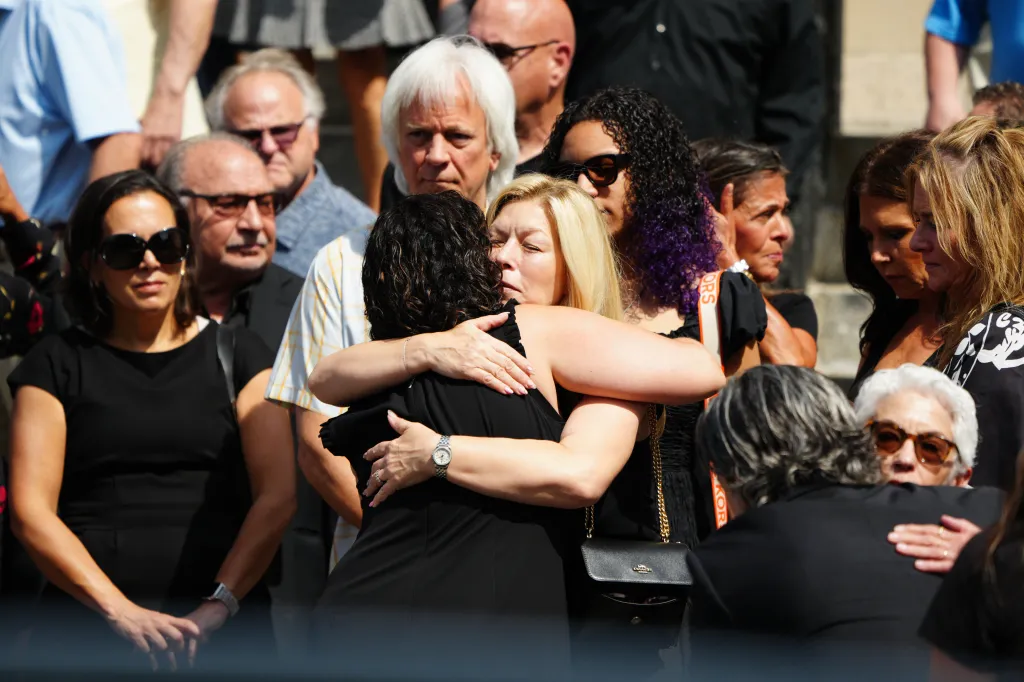 Mourners embrace at the funeral of actor Vincent Pastore.