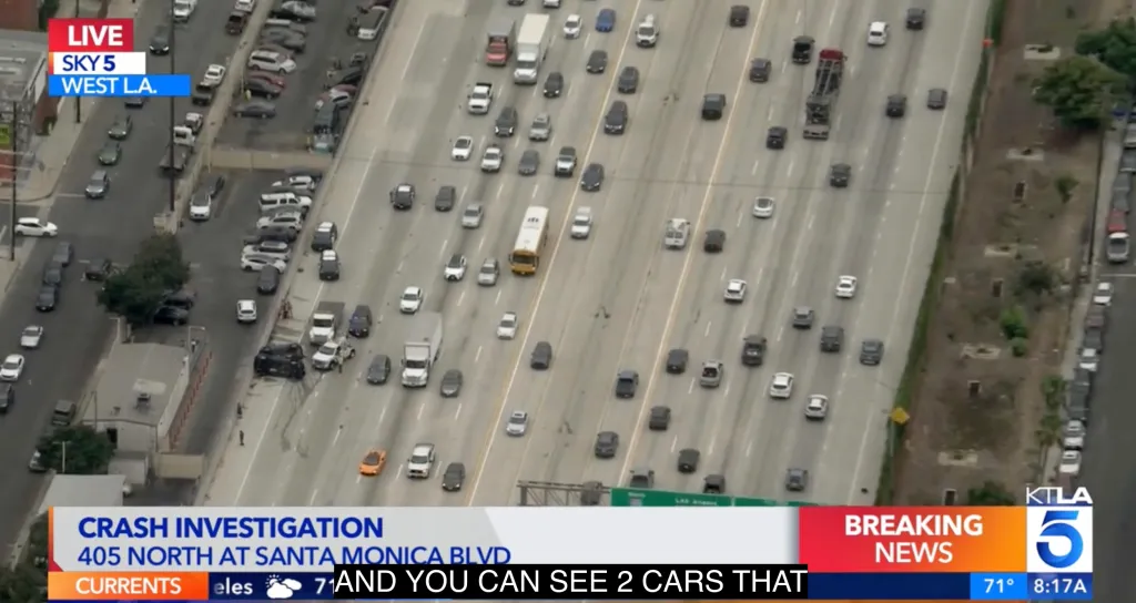 Aerial view of a traffic jam on the 405 Freeway with two overturned cars on the shoulder.