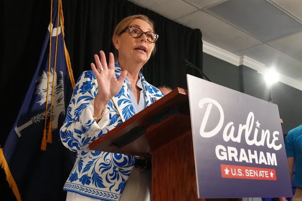 Darline Graham speaking at a podium with a campaign sign for U.S. Senate.