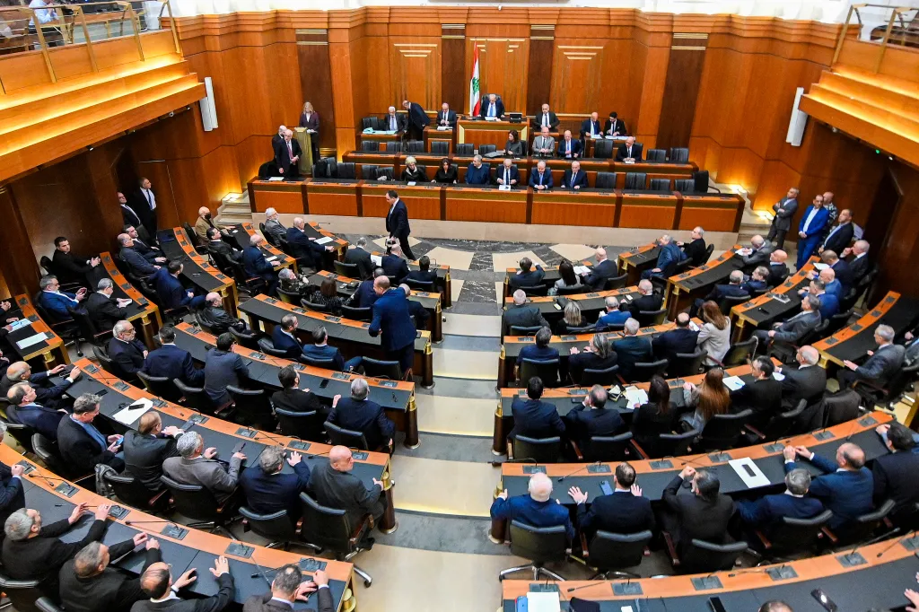 Lawmakers attending a parliamentary session in a wood-paneled chamber.