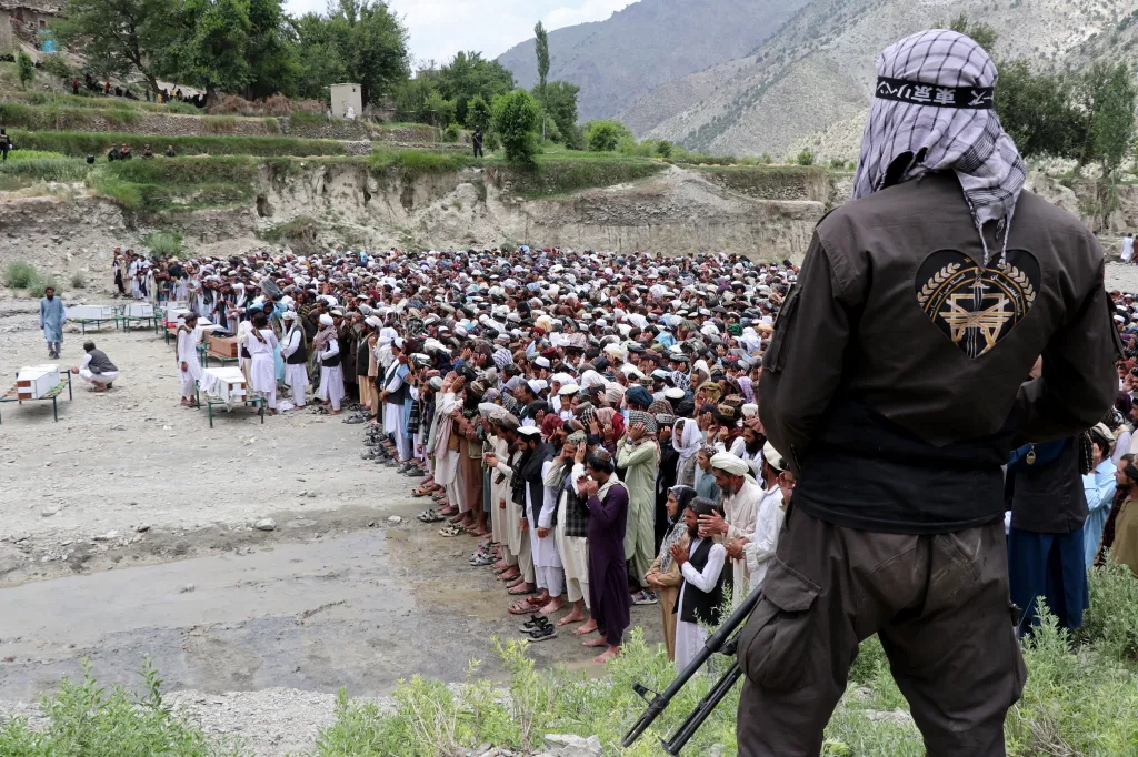 A Taliban personnel stands guard as Afghan men gather to offer funeral prayers for Pakistani airstrike victims at Mani village in Spera district, Khost province on June 10, 2026.