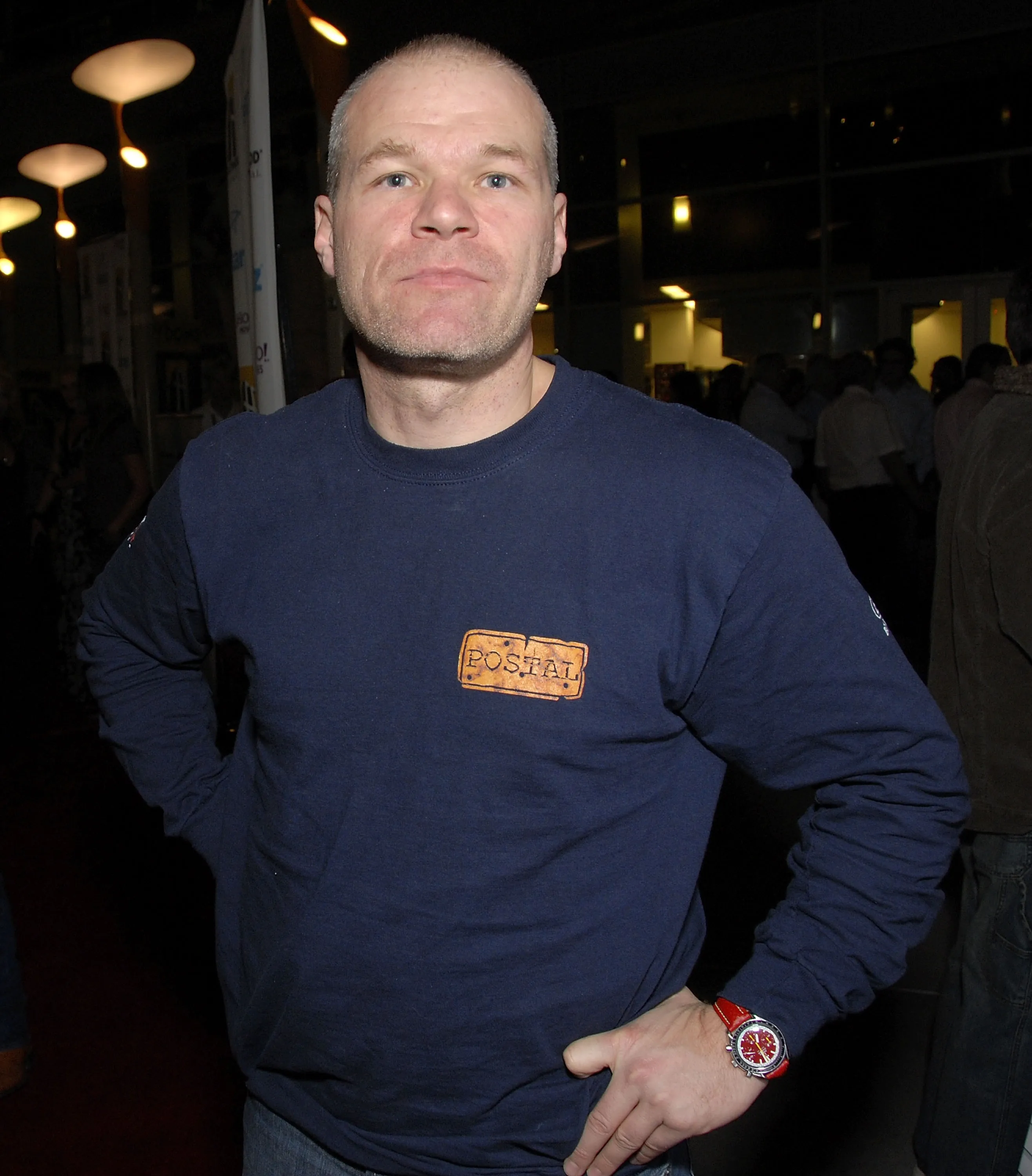 A man in a navy blue shirt with a "Postal" logo on it.