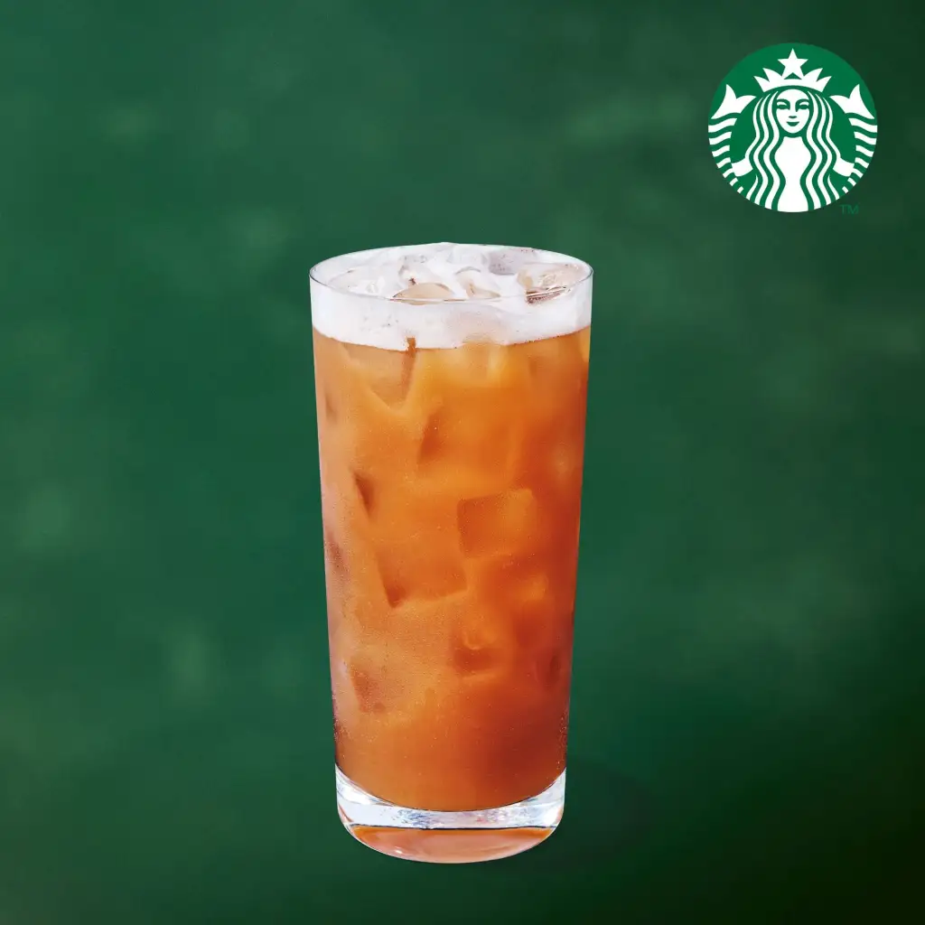 A tall glass of iced tea with foam on top, and a Starbucks logo in the upper right.
